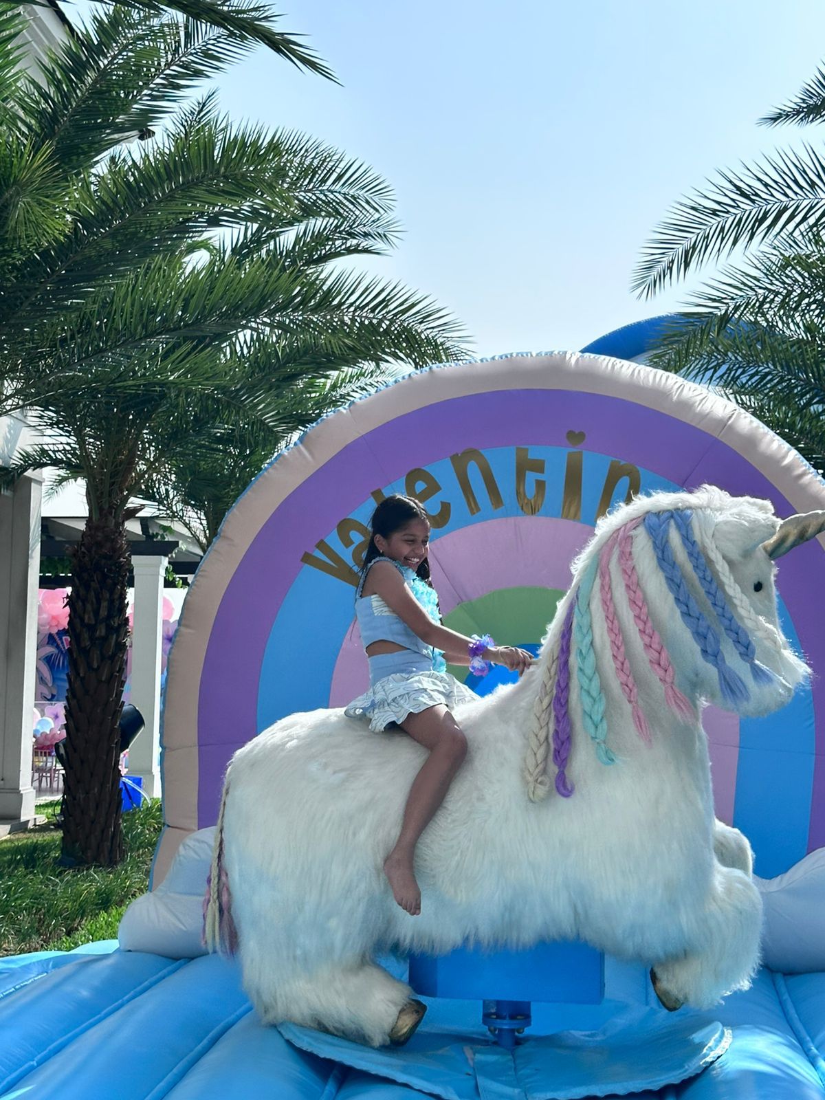 Niña feliz montando el unicornio inflable mecánico de Happy Hoppers en una fiesta en Samborondón.