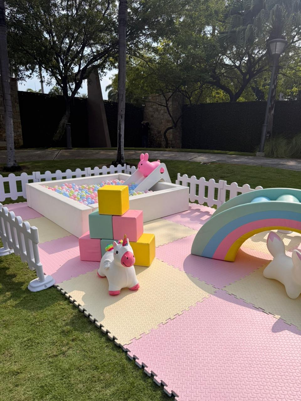 Zona soft-play con bloques de colores, arcoíris y piscina de pelotas para bebés.